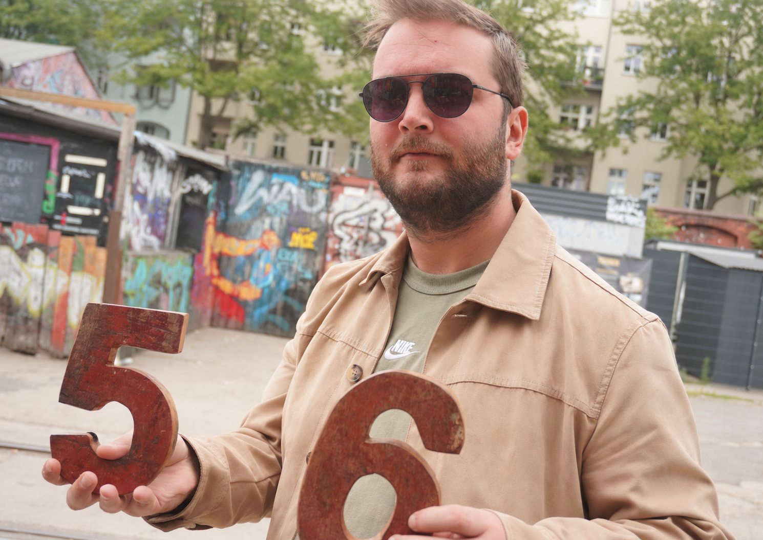 Jean, the founder of Junk Filter, outdoors holding wooden numbers